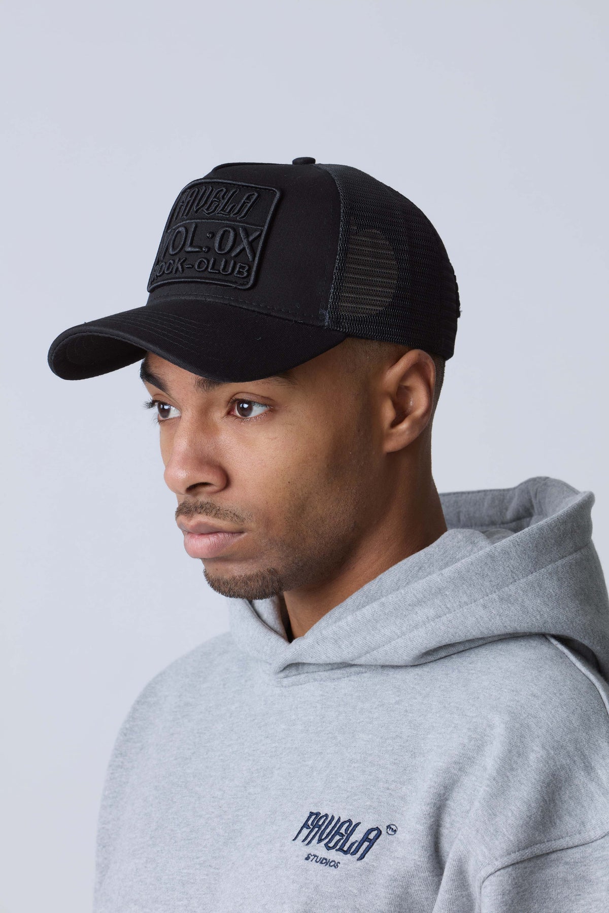Model wearing a black Favela cap and grey Favela Studios hoodie