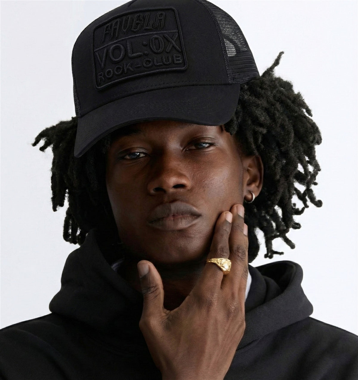 Model wearing a black Favela cap and hoodie